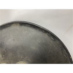 Indian black lacquered hide shield/dhal, of circular convex form with strongly outward-turned brim, fitted at its centre with four metal bosses, each of hemispherical form, with traces of silvered foliate decoration, the bosses corresponding on the inside with four iron rings for enarmes D49cm