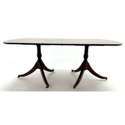 Regency style cross-banded mahogany twin pedestal extending dining table, shaped and fluted brass capped supports 