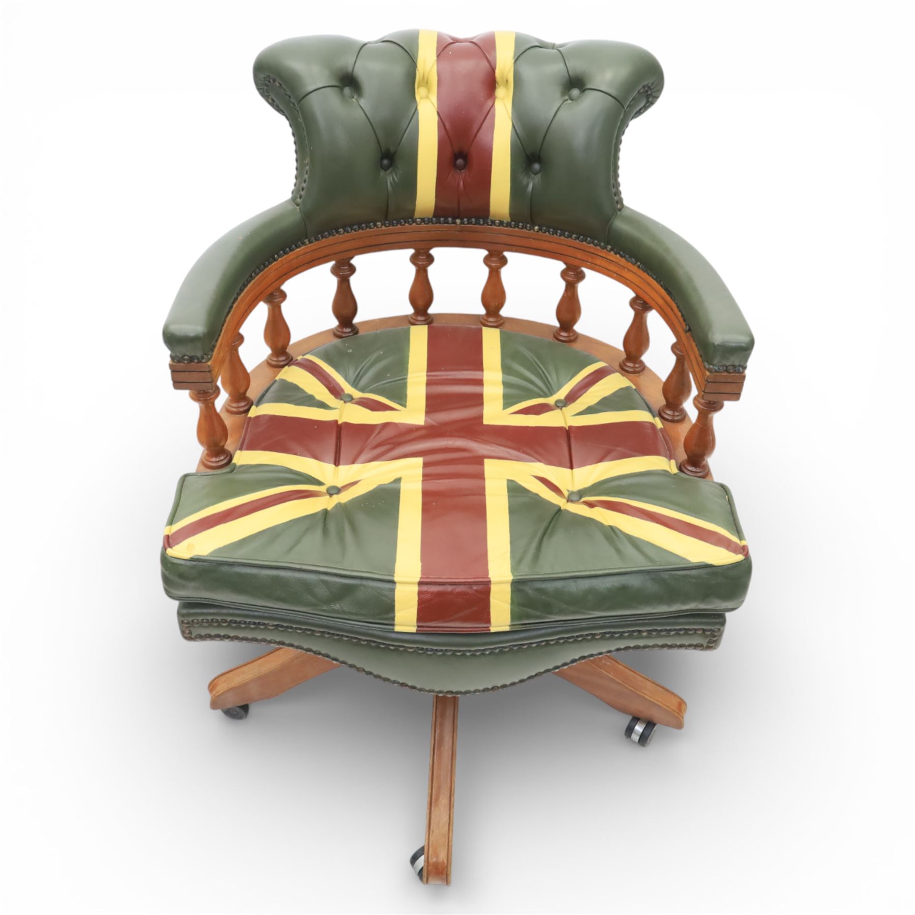 Late 20th century captain’s swivel desk chair, button upholstered back and seat in green leather with Union Jack motif panels, brass stud edging, curved padded arms with turned spindle supports, revolving and height adjustable action, on a five branch wooden base with castors