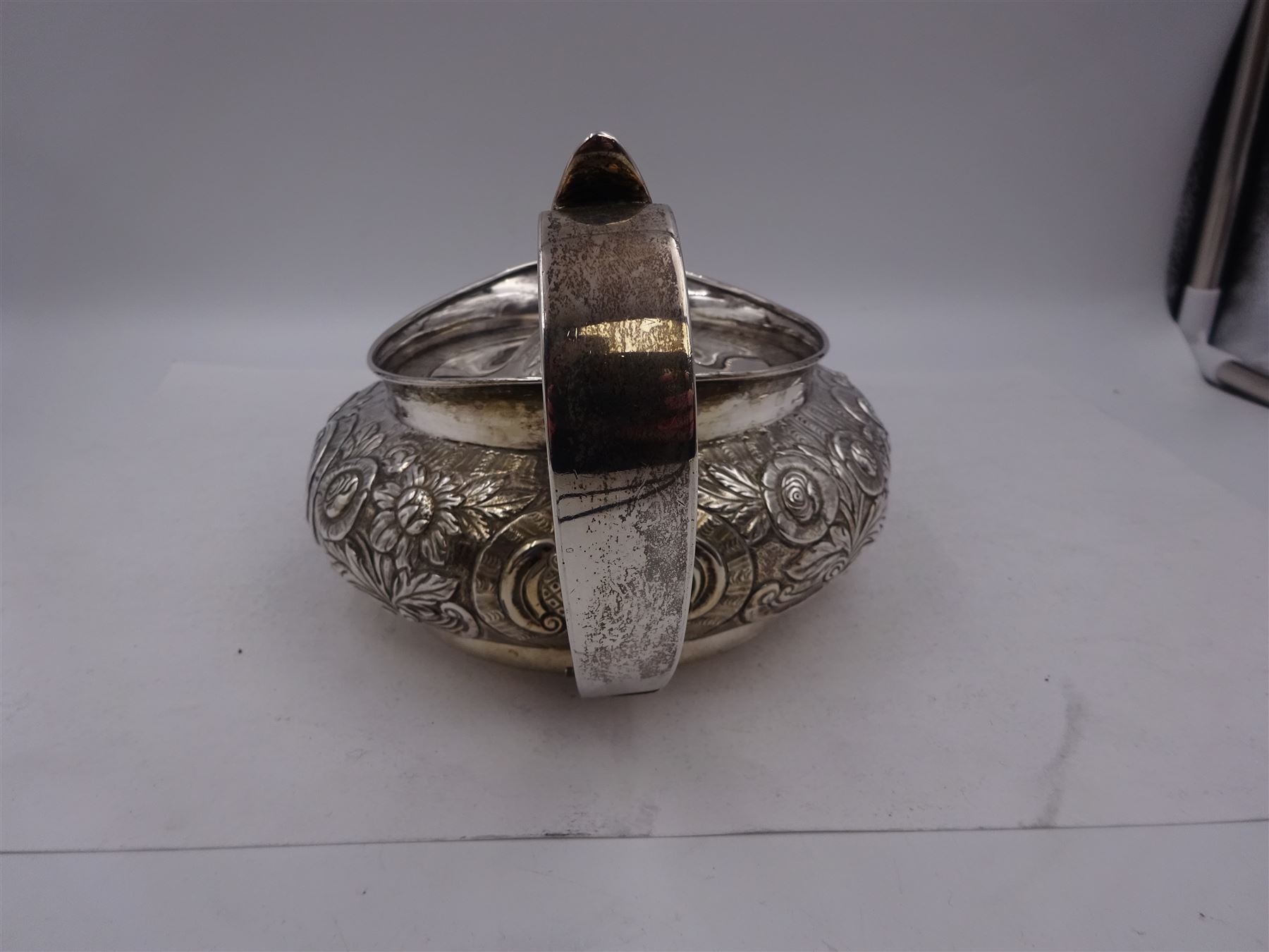 George III Irish silver teapot, of squat circular form, the body with repousse and chased floral and C scroll decoration, with capped C handle and ivory insulators, engraved to base 'Presented to Troop Sergeant Major John Percival, of the 4th Dragoon Guards by Alex D. Tait, Esq, late Captain in that corps as a mark of approbation of his steady and upright conduct when Sergeant Major of his Troop, Dublin, June 2nd 1843', hallmarked William Law, Dublin 1817, H12.5cm, This item has been registered for sale under Section 10 of the APHA Ivory Act