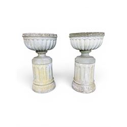 Four 20th century good quality weathered cast stone pedestal urns, circular lobed bowls with rope twist and lattice border, raised on squat base with fluted columns