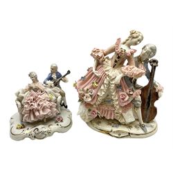 Dresden figure group, modelled as a man playing an instrument to a woman in a lace crinoline dress, upon a gilt rococo decorated base, together with a Dresden style figure group, modeled as a man playing the cello to a woman in a pink lace crinoline dress, tallest example H18.5cm 