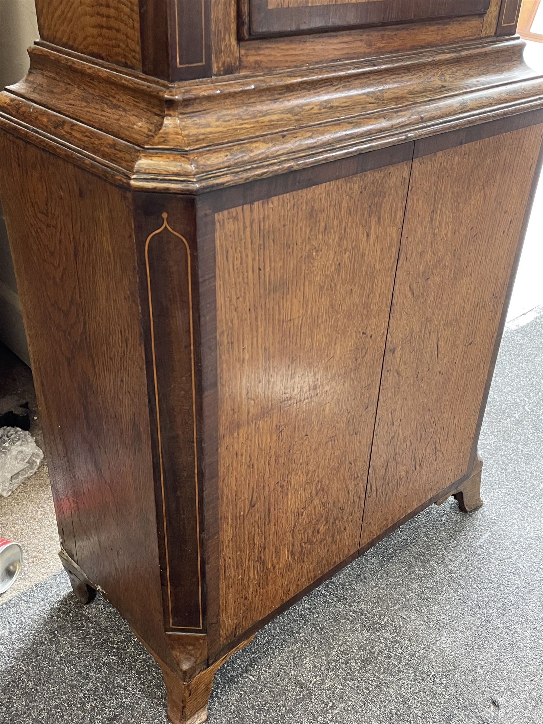 Early 19th century oak and rosewood banded longcase clock, scrolled pediment over stepped arch hood door, enamel painted dial indistinctly signed for a Penrith maker, 30-hour movement striking on bell