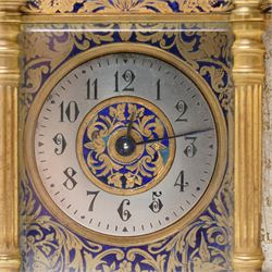 French-late 19th century combination brass carriage timepiece with barometer, thermometer and compass, with a fluted T bar handle and eight matching columns with turned finials, bands of fretted brass to the base and cornice and conforming decoration to the dial masks and dial centres, with silvered chapters to the time dial and barometer and a mercury thermometer between, the top with a circular bevelled viewing glass to the escapement and compass to the other, with a single train 8-day movement and cylinder platform escapement.  With key.