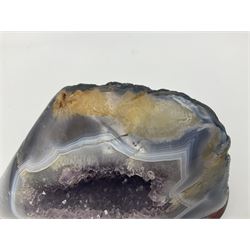 Amethyst crystal geode cluster, with well-defined crystals of various sizes, upon a carved wooden stand, H12cm, L20cm