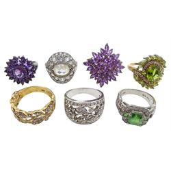 Seven silver and silver-gilt dress rings including two cubic zirconia flower open work rings, cubic zirconia cluster and a peridot cluster ring, all stamped 925