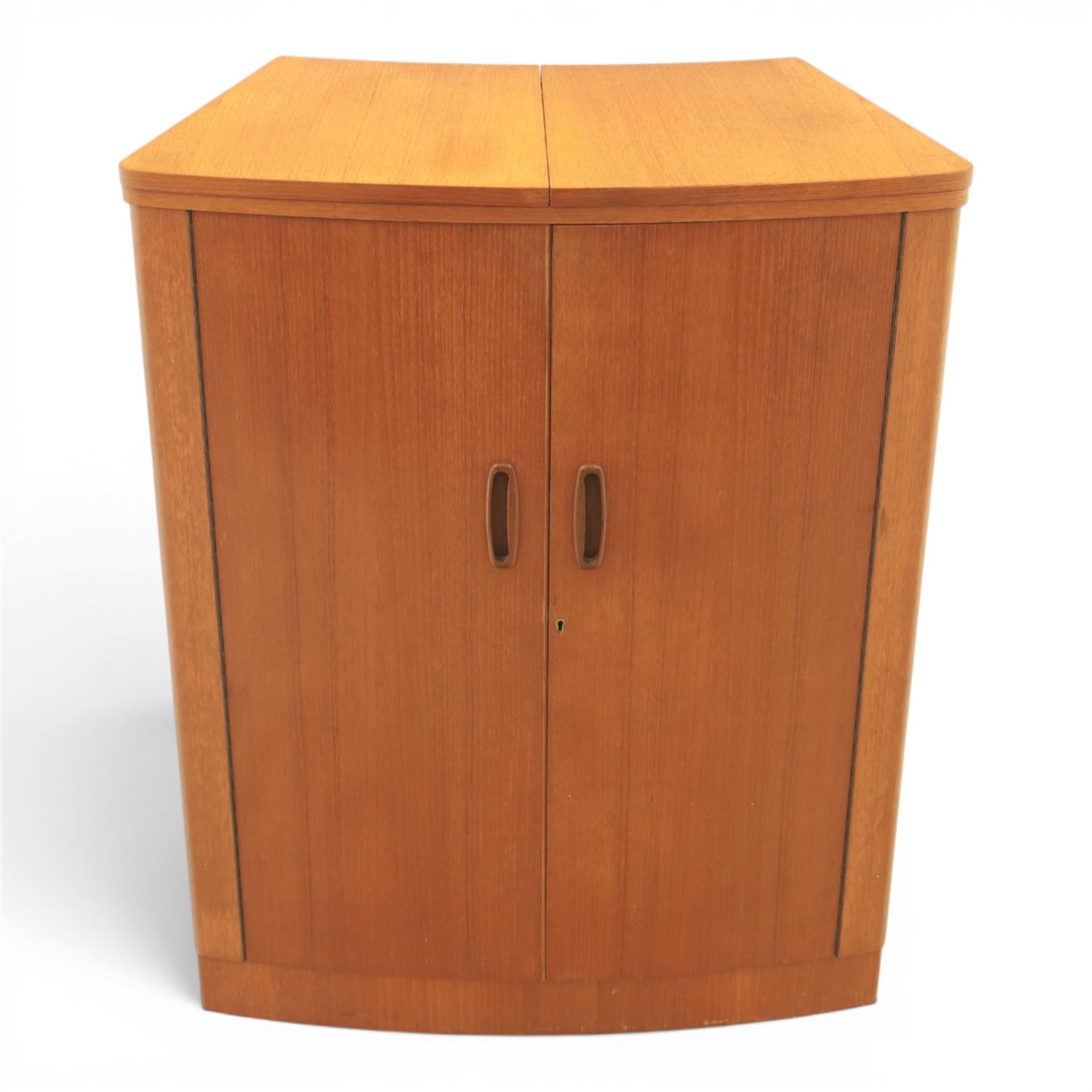 Turnidge of London - Mid 20th century teak drinks cabinet, shaped top with hinged fold-out side sections, twin doors with recessed handles enclosing fitted shelving and serving surfaces, sliding glass doors to the back, on a plinth base above castors