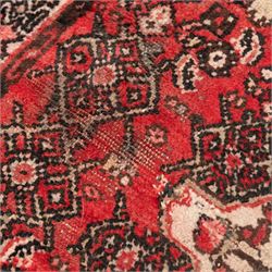 Persian crimson ground runner rug, the field decorated with repeating Herati motifs around an ivory pendant medallion, stepped ivory spandrels with stylised floral ornament, enclosed by a dark ground star border and narrow guard stripes