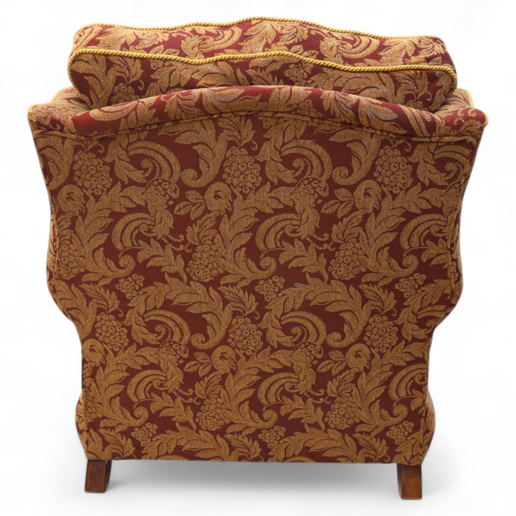 Duresta – pair of armchairs, upholstered in red and gold damask fabric with piped edges, scroll arms and loose feather-filled cushions, raised on turned wooden feet with brass castors
