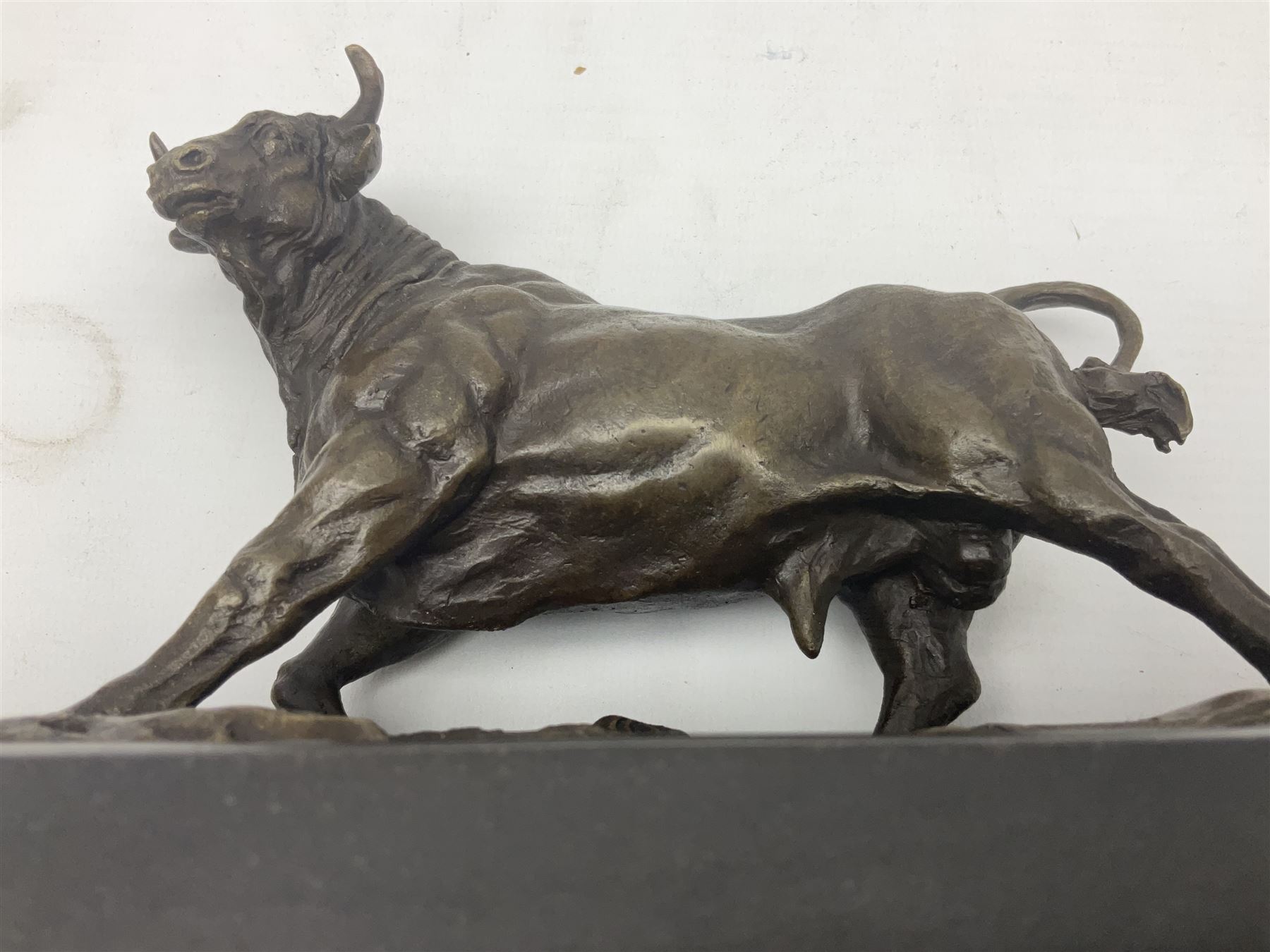 Bronze figure, modelled as a prancing bull, upon a naturalistic base signed Mils and with foundry mark, raised upon a rectangular marble base, overall H14cm