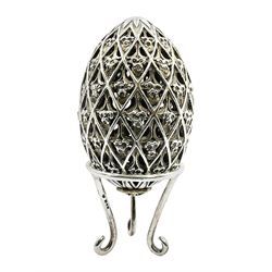 Modern silver limited edition Easter egg, no. 70/500, the openwork lattice body decorated with gilded panels of flower heads, opening to reveal a gilt interior, upon silver stand with three scrolling pad feet, each hallmarked St James House Company, London 1979, height including stand 8cm