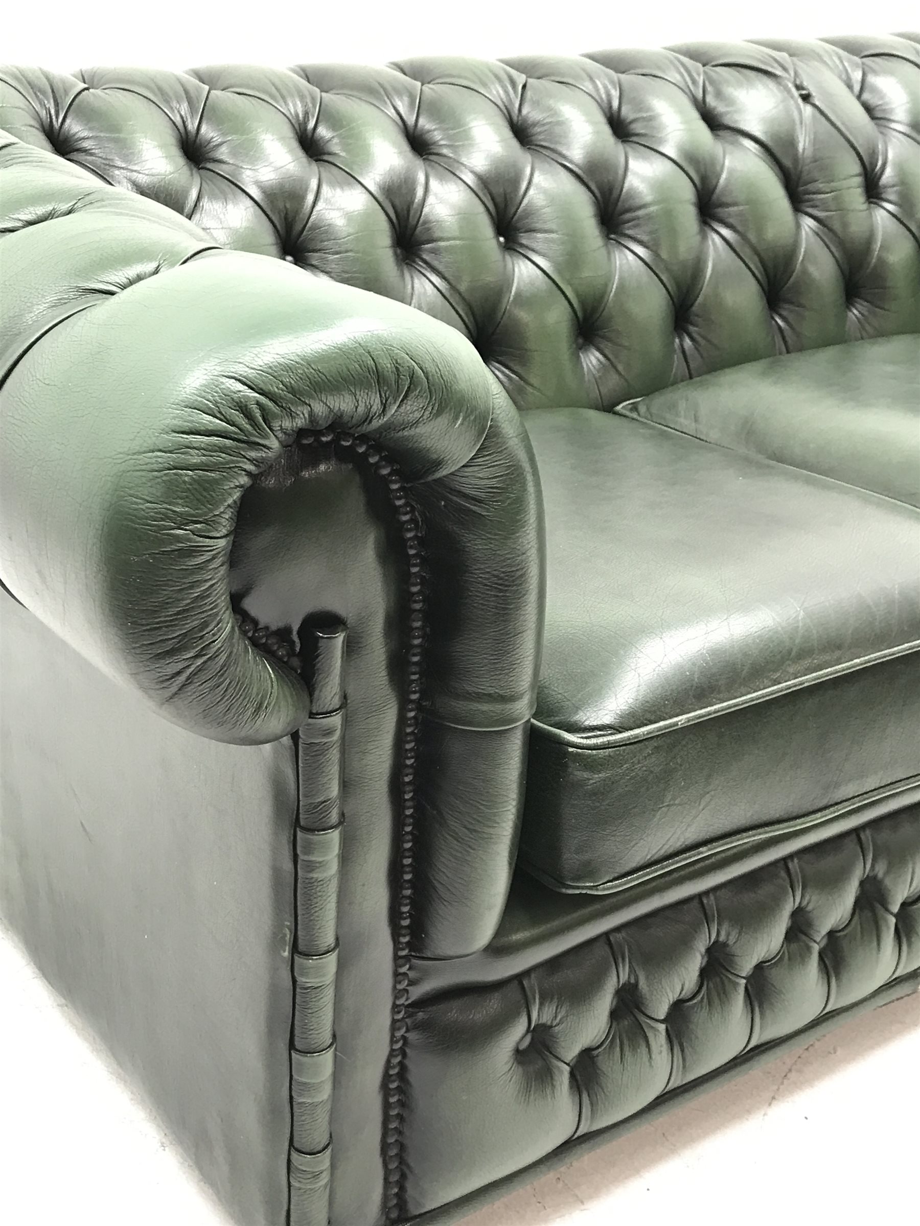 Three seat Chesterfield sofa upholstered in deeply buttoned green
