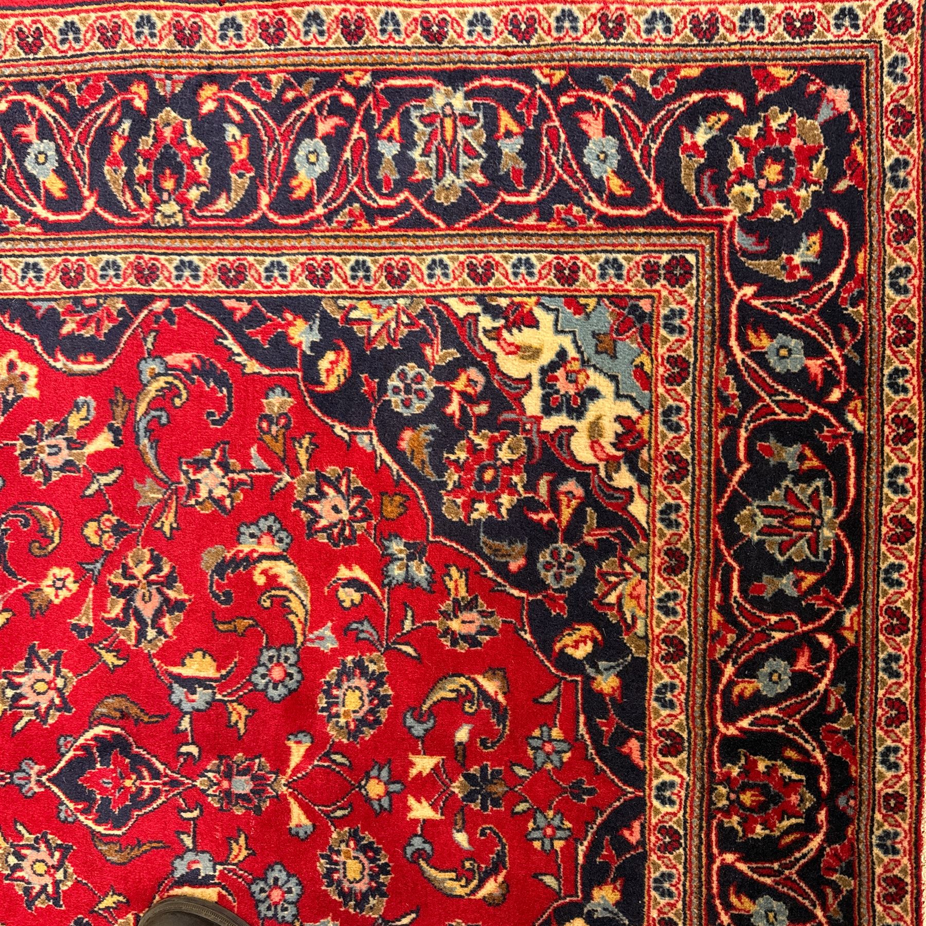 Central Persian Kashan rug, crimson ground with central medallion with  quarter medallions in each corner and decorated with floral sprays and palmettes, dark blue main border with repeating palmette and vine pattern   framed by small guard border with floral meanders 