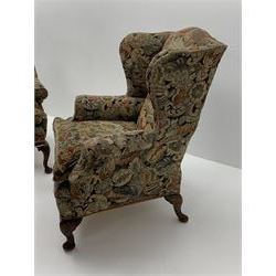 Matched pair early 20th century Queen Anne style wingback armchairs, walnut framed, sprung seats with seat cushions upholstered in needle work cover, shell carved cabriole front feet