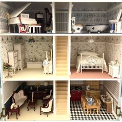 Georgian style wooden double fronted three-storey dolls house with pale blue stucco finish under a faux tiled roof with two chimney stacks, the double hinged front opening to reveal six fully decorated rooms with floor coverings, central staircase, porcelain fitted bathroom, kitchen with deep white sink and Aga cooker, electric lighting with adaptor, fully furnished with French style and other furniture, grand piano etc, and comprehensive range of accessories H82cm W61cm D31cm