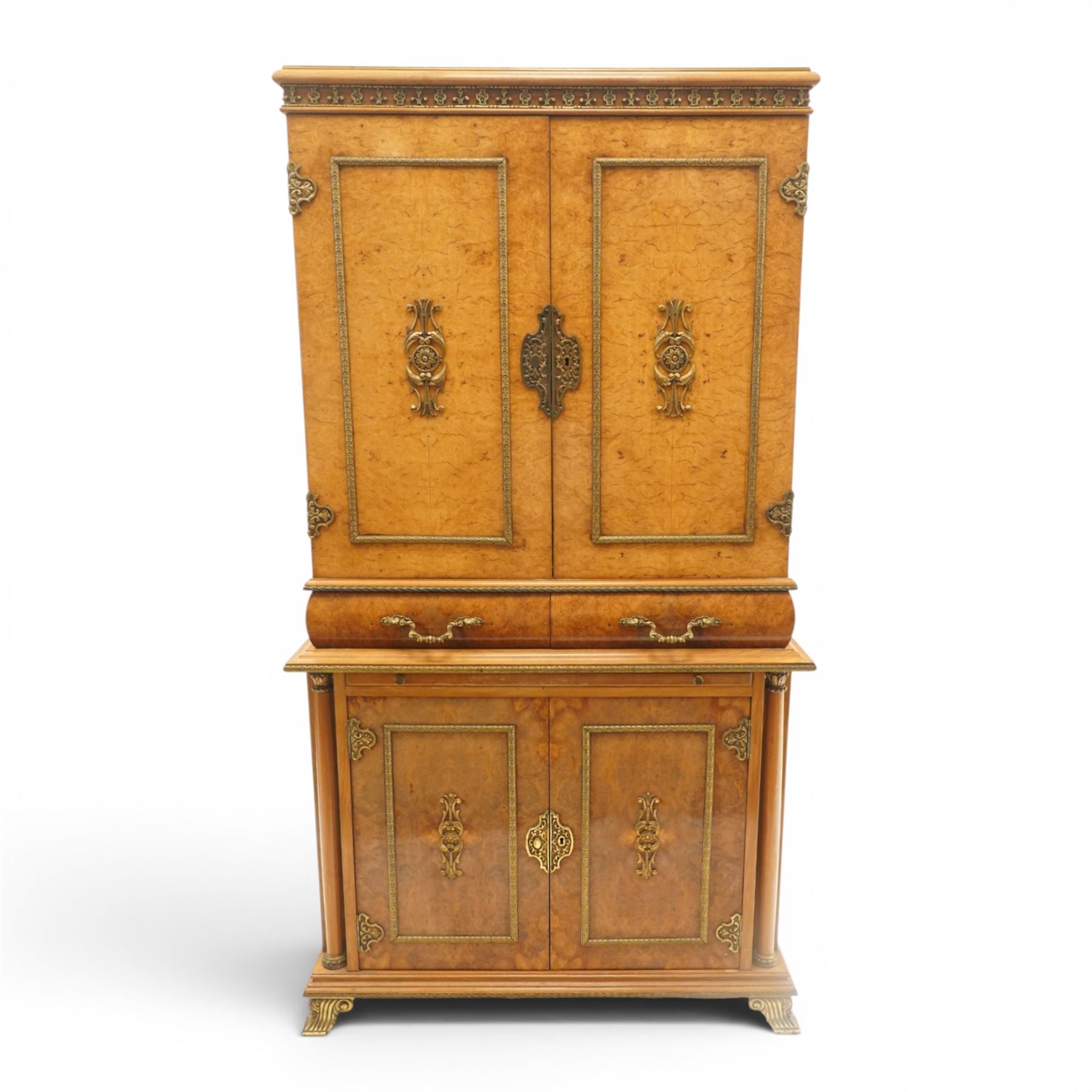 Early 20th century Art Deco burr maple mirrored drinks cabinet, rectangular top with gilted cornice, twin cabinet doors with gilt escutcheons, enclosing a mirrored interior with shelves behind the doors, marble base to the top section above two short drawers over a marble inset slide, the lower cabinet with cabinet doors flanked by pilasters, raised on gilted bracket feet 