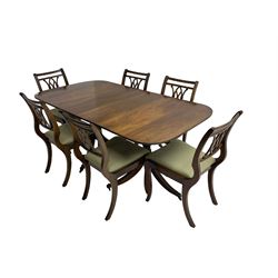 Regency design mahogany twin pedestal dining table, rectangular top with reeded edge, acanthus carved turned column terminating in reeded tripod base with hairy paw feet and castors (W172cm D92cm H75cm) and set eight (6+2) Regency design mahogany dining chairs, pierced back with scroll design, seat upholstered in patterned laurel green fabric, raised on reeded sabre supports (W48cm H88cm)