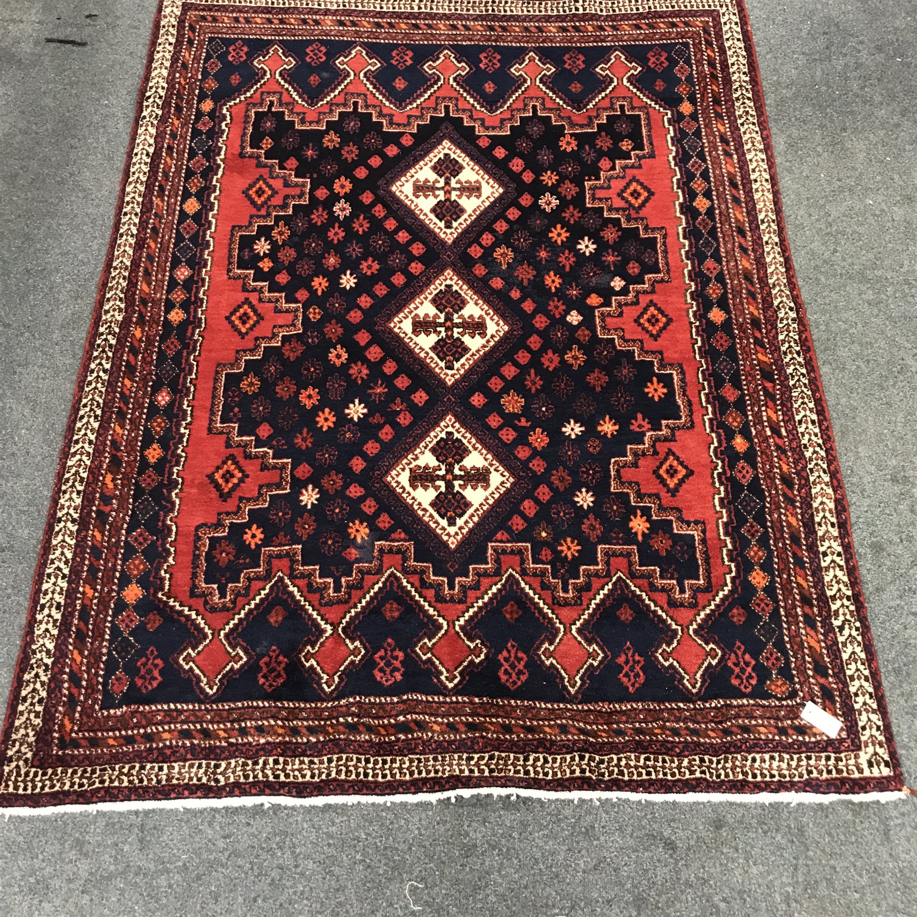 Persian style red and blue ground rug, three central diamonds