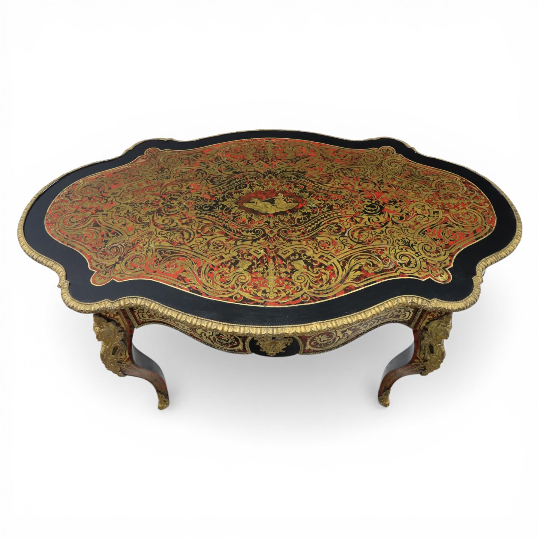 Late 19th century boulle work centre table, shaped serpentine top decorated with brass inlay on red tortoiseshell ground within ebonised border, fitted with single frieze drawer, on cabriole supports with gilt metal mounts and mask terminals