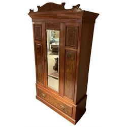 Late Victorian walnut wardrobe, carved arched pediment, fitted with single bevelled mirror door, flanked by carved and figured panels, enclosing hanging rail and hooks, single drawer fitted to base