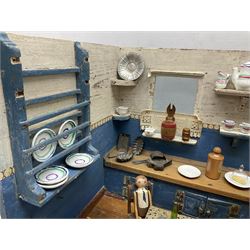 Late Victorian German white and blue painted pine diorama of a kitchen interior, the long work surface with inset wash bowl and cupboards under, various fitted shelves, tin-plate cooking range, wooden figure seated at a tin-plate table and well-stocked with various age ceramic, metal and wooden accessories L50cm H31.5cm D30cm