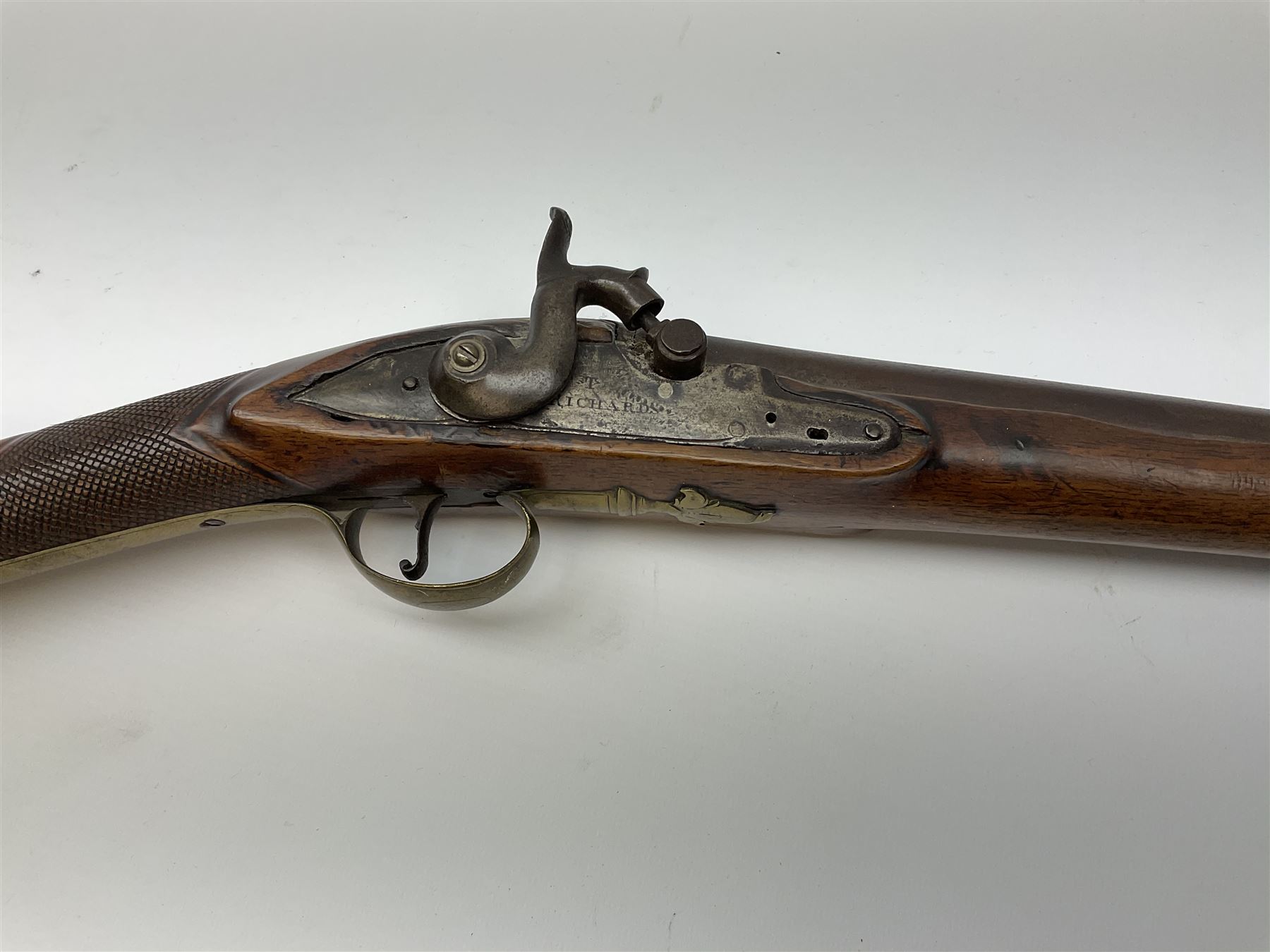 Early 19th century 15-bore flintlock converted to percussion cap fowling piece, the lock stamped T. Richards, walnut half stock with brass fittings including trigger guard with pineapple finial and 91cm barrel with ramrod under L129cm overall