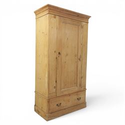 Traditional waxed pine single wardrobe, featuring single panelled door above base drawer, loop handles
