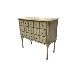 Washed finish pigeon hole or apothecary style chest, fitted with fifteen drawers, raised on fluted tapered supports 