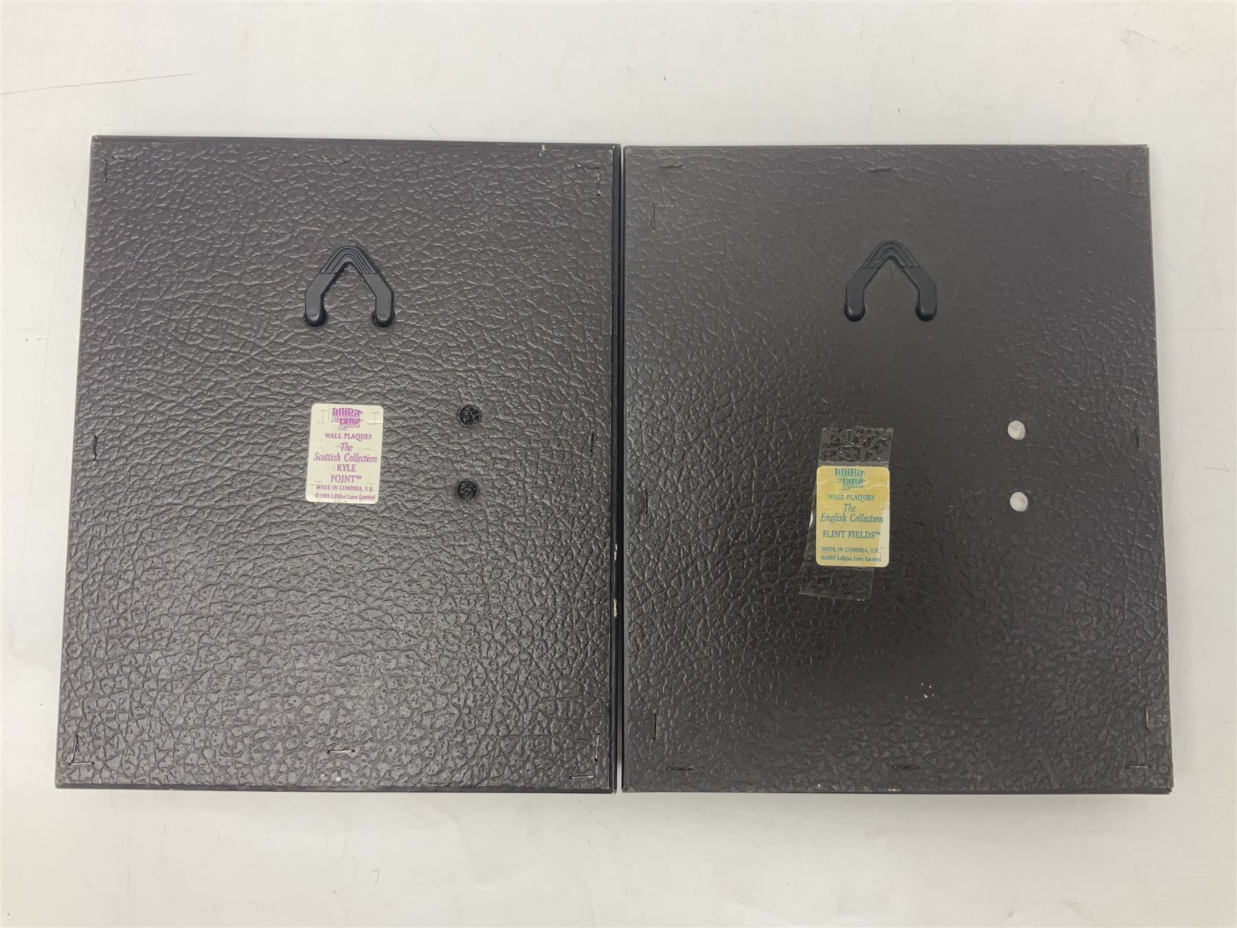 Nine Lilliput Lane framed wall plaques, including Fell View, Battleview, Catslide Cottage, Ashdown Hall and Shannon's Bank, together with three smaller circular framed Lilliput Lane plaques