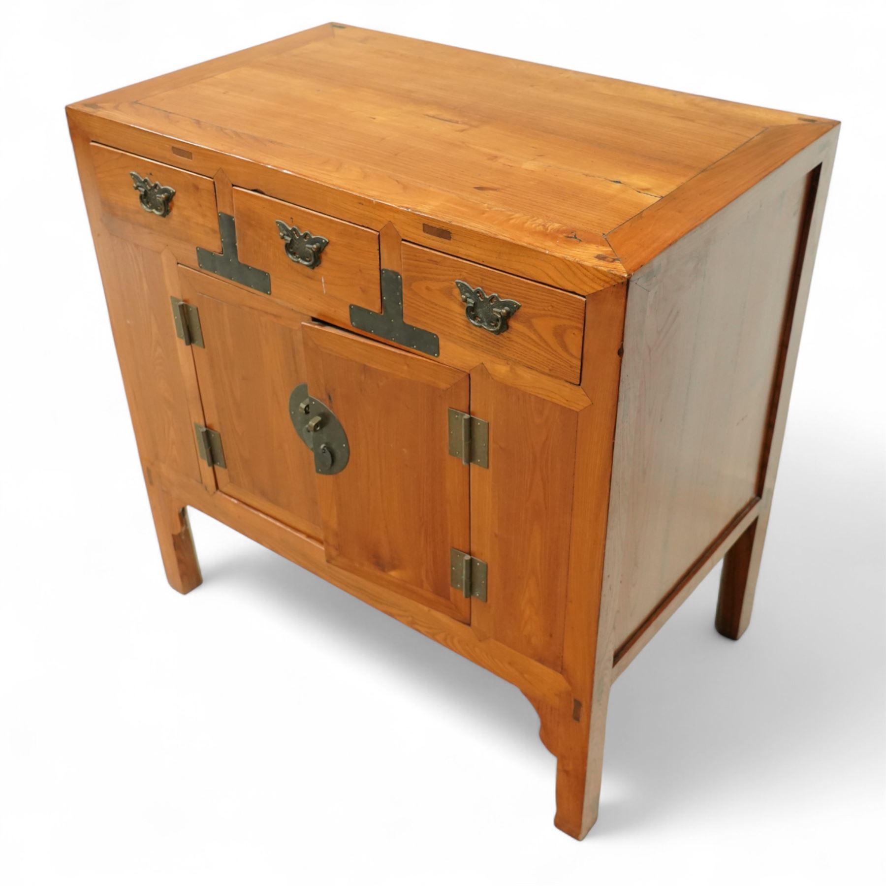 Mid-20th-century Chinese elm side cabinet, rectangular top above three drawers and a pair of panelled cupboard doors, mounted with traditional brass butterfly form handles and pierced circular lock plate 