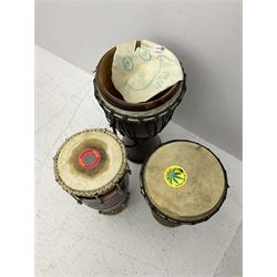 Three wooden and hid bongo drums, largest example H62cm