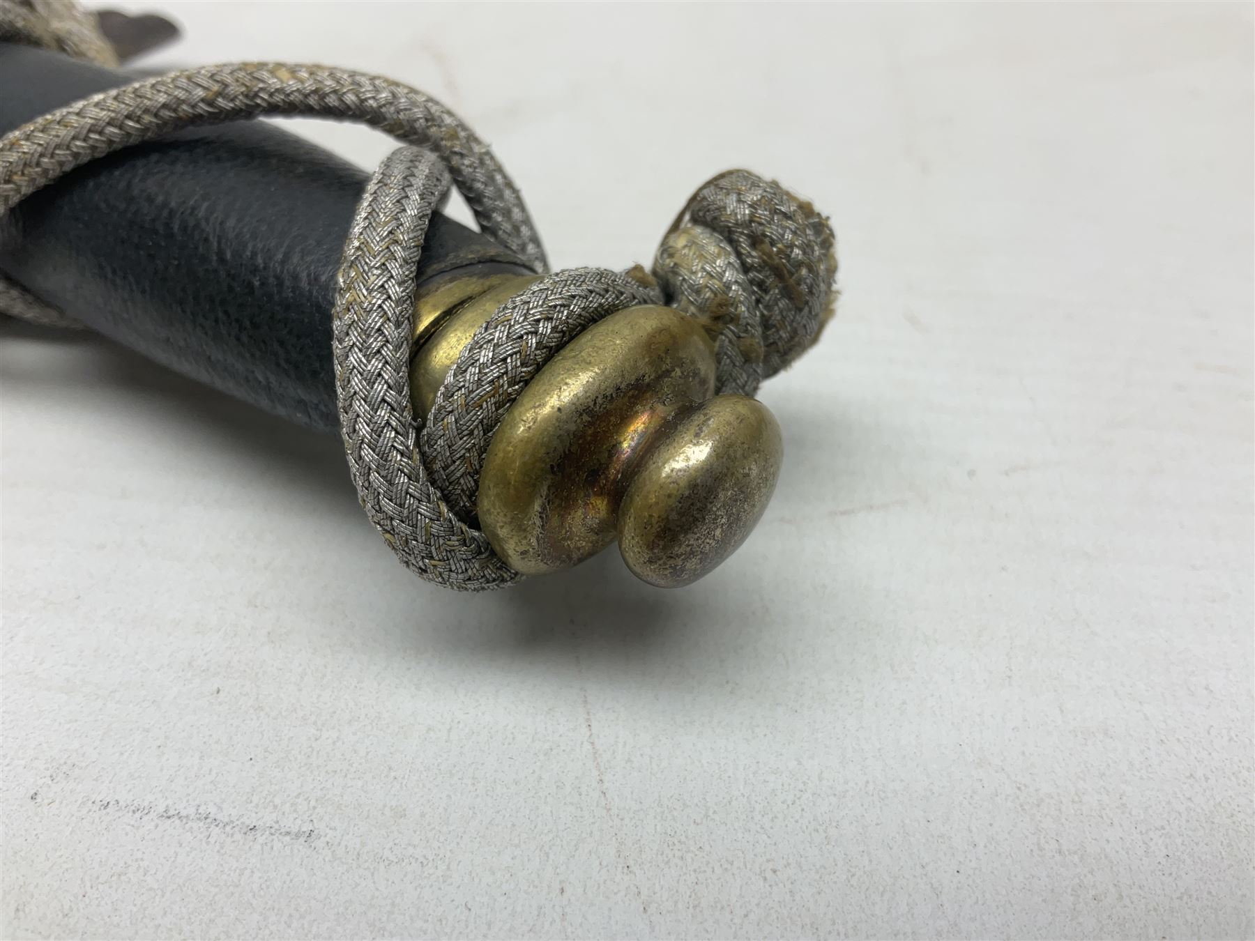 German Paul Weyersberg & Co Solingen DLV flyers dagger with 18cm steel blade, plated brass/tombac downswept cross-piece and pommel and leather covered grip, in leather and plated brass/tombac scabbard with leather hanger strap and silvered knot L35cm overall. Auctioneer's Note: After WWI Germany was forbidden an air force by the Treaty of Versailles however the Deutscher Luftsport-Verband (German Air-sport Association) was formed in March 1933 from various sports flying clubs and had branches for aeroplane, gliding and balloon flying. Under cover of the sporting DLV, many future Luftwaffe pilots trained to fly. DLV was embodied with the NSKK in March 1935 and on 1st March 1937 Luftwaffe was formed.