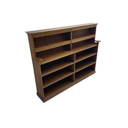 20th century oak double bookcase, ten shelves fitted with hinged spine covers, on moulded plinth base