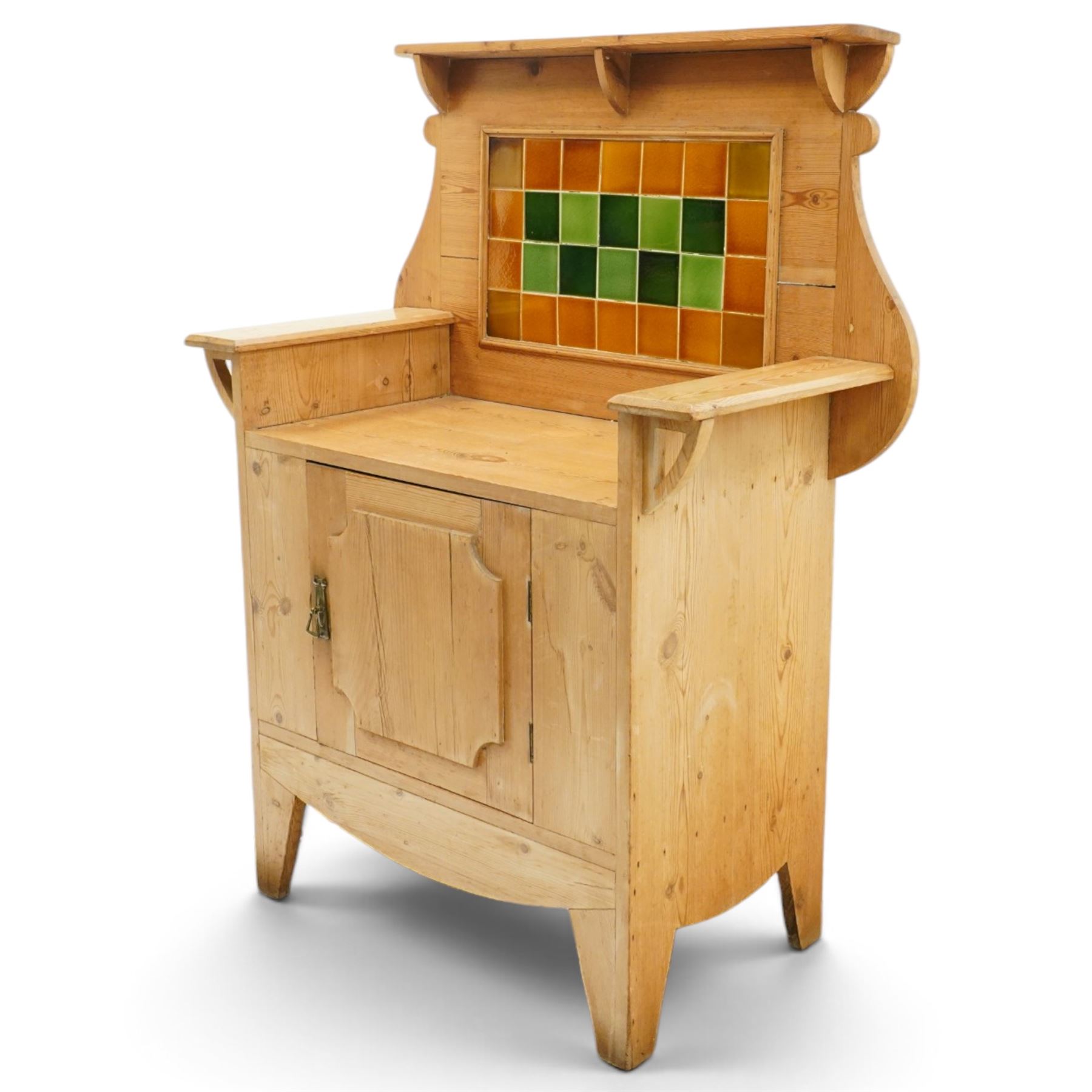 Arts & Crafts pine kitchen cabinet, raised tiled back with projecting shelf and shaped side supports, rectangular work surface above single cupboard door with moulded panel, on square supports