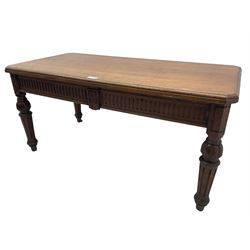 Late 19th century oak library table, moulded rectangular top with canted corners, fitted with two frieze drawers with fluted facias, on lobe carved and fluted turned supports 
