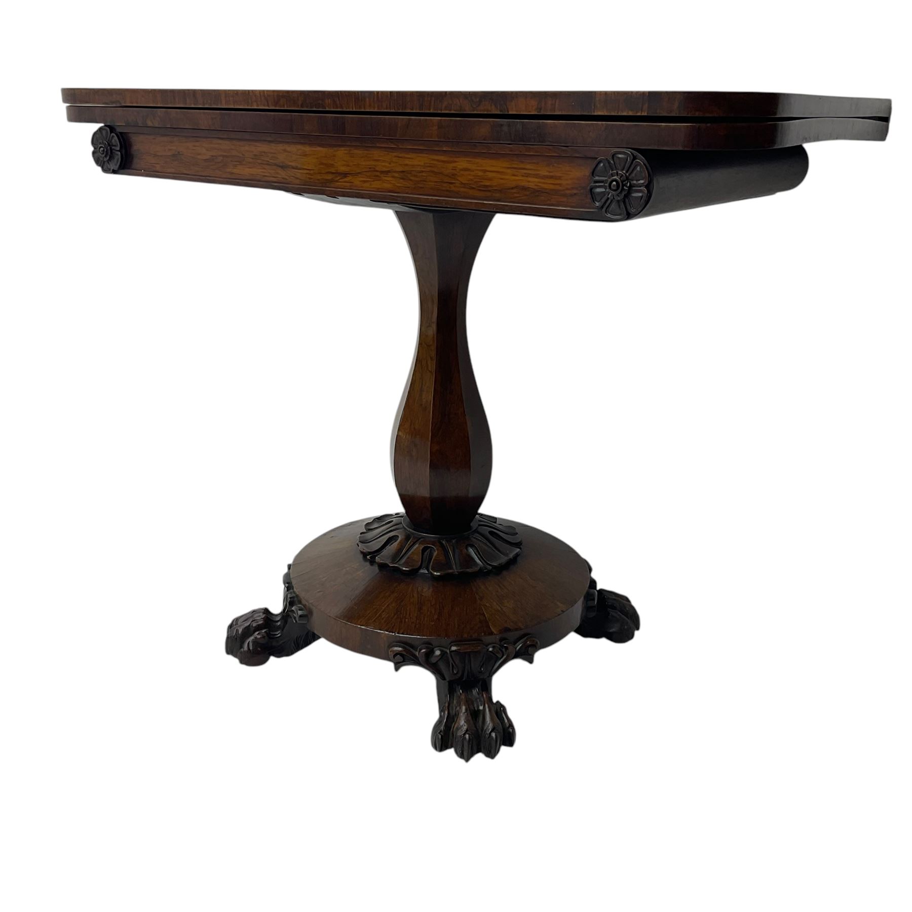 Victorian mahogany tea table, rectangular top with rounded corners, folding and swivelling to reveal interior surface, supported on a faceted baluster-shaped column, raised on a circular platform base with carved acanthus details, ending in four lion paw feet