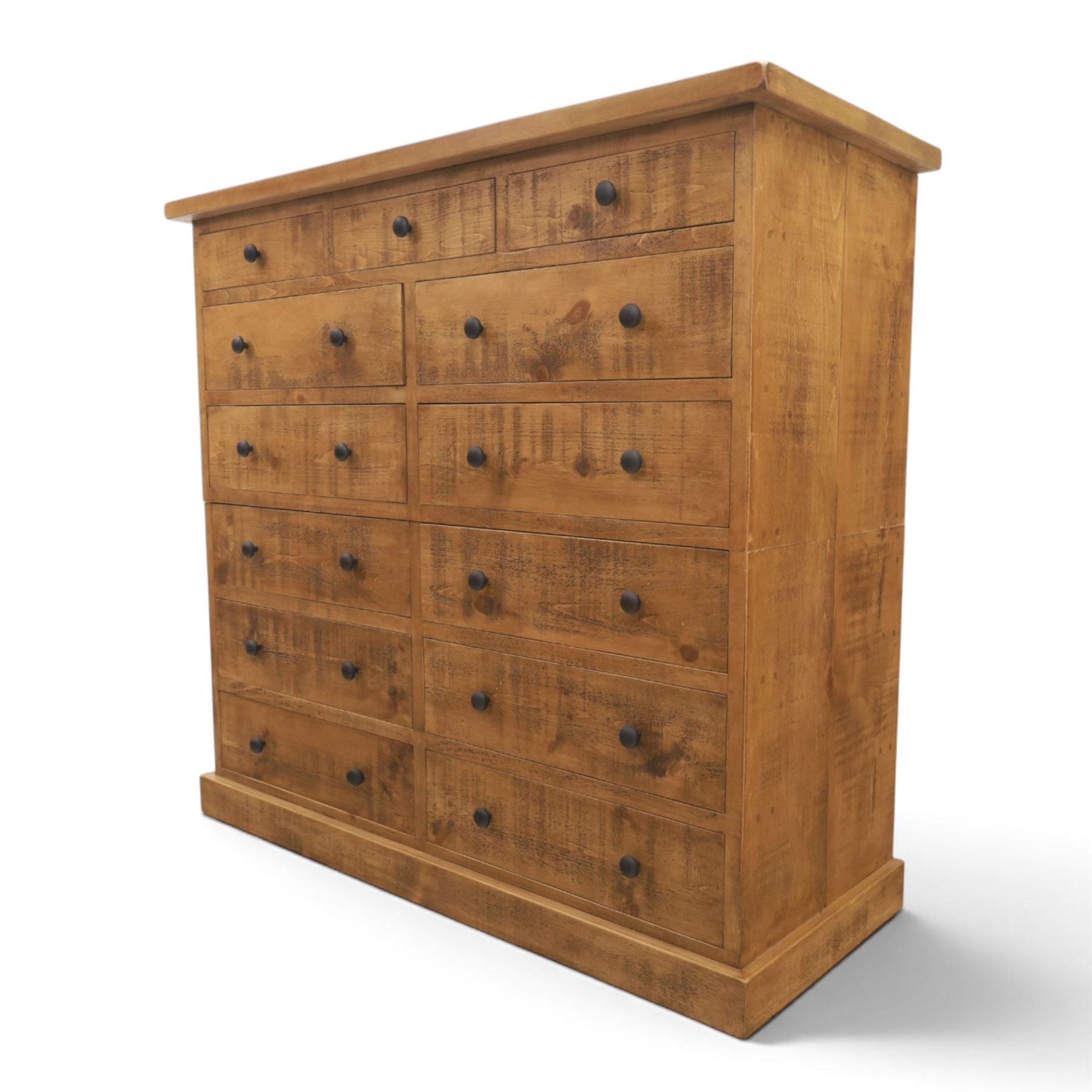 Indigo Furniture - large rustic oak combination chest, three drawers above ten drawers, with blackened pulls, raised on a plinth base