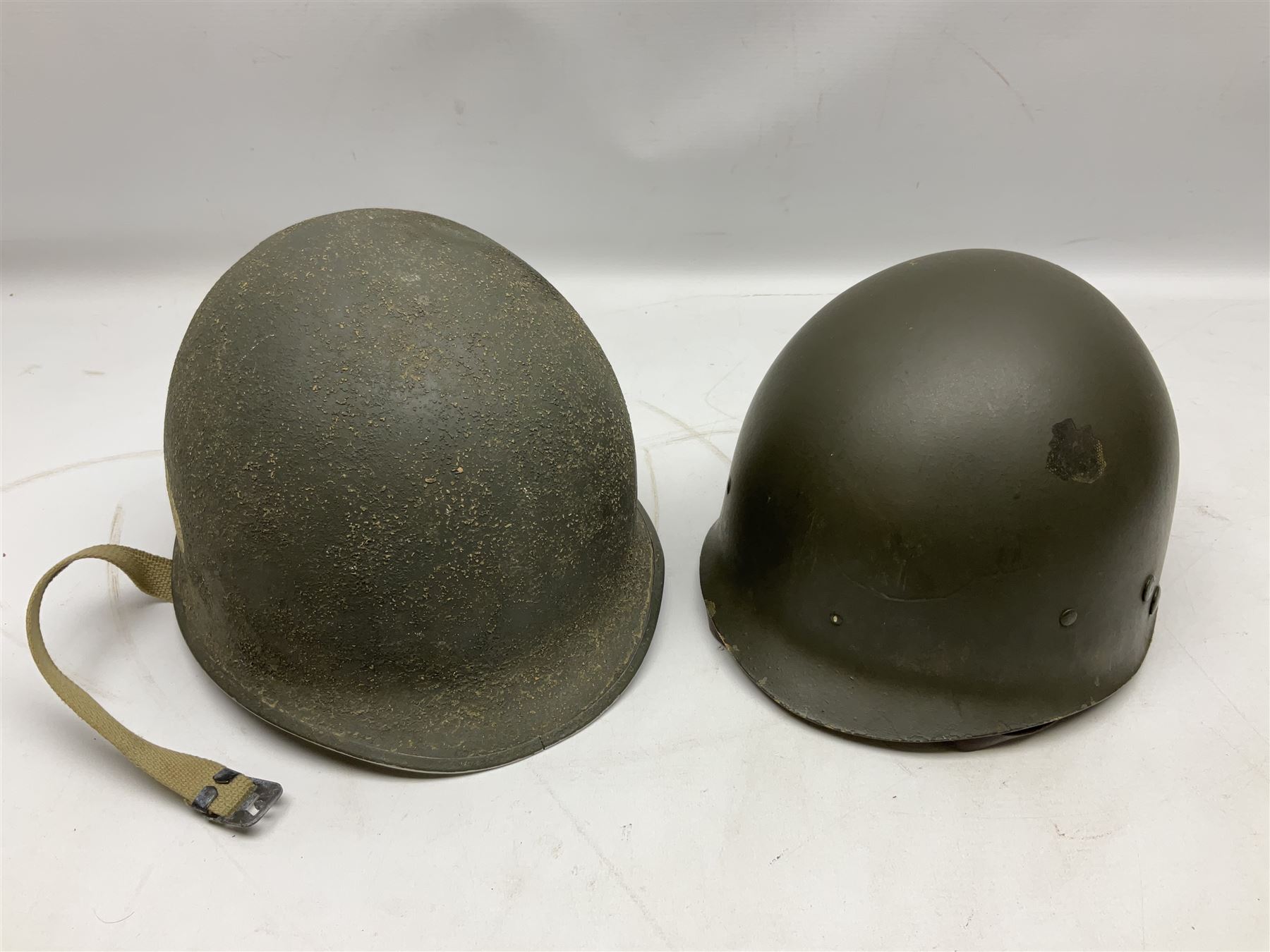 American first type paratrooper helmet with post-WW2 strap and D-rings and later 1944 liner bearing Firestone Tyre and Rubber Company mark; green textured finish