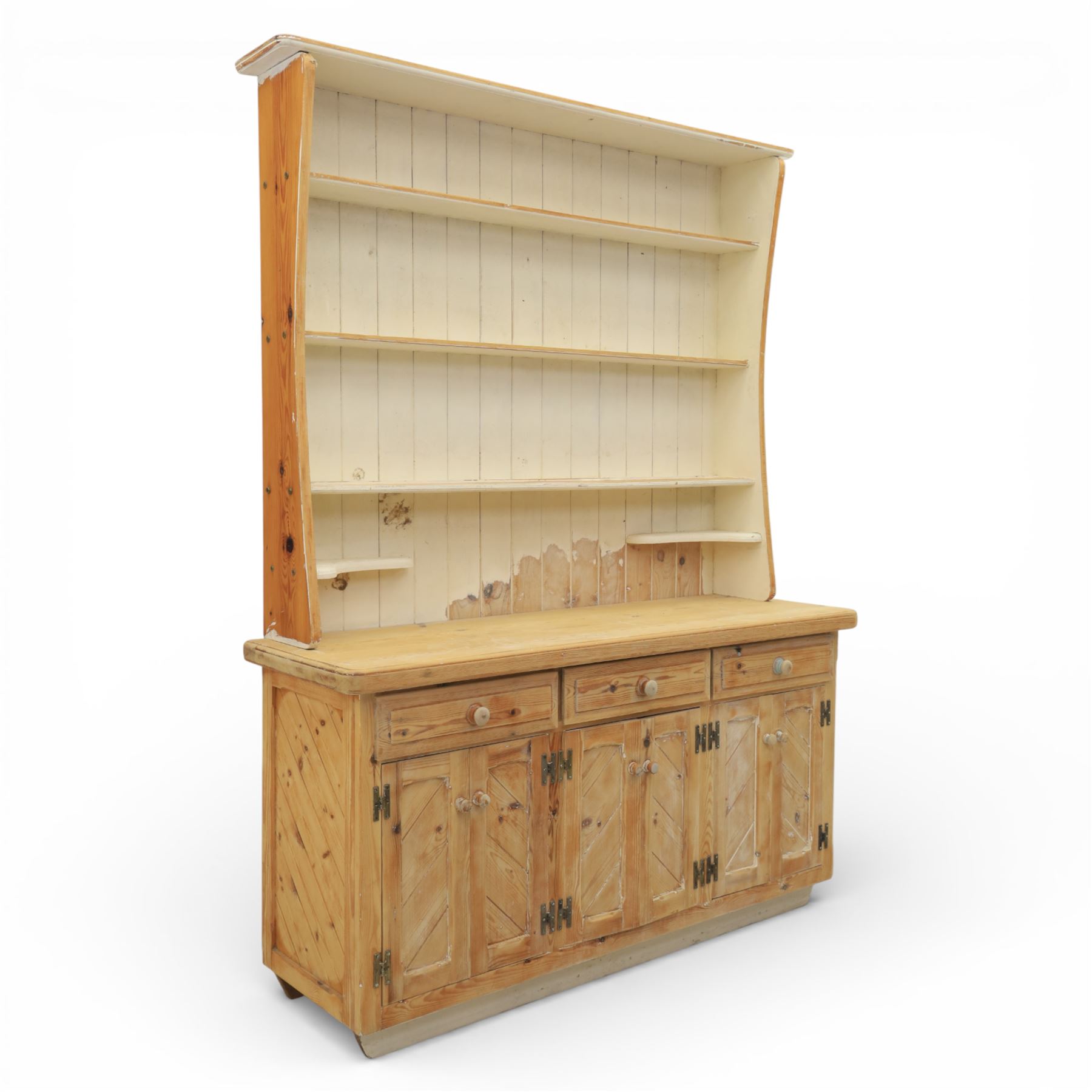 Late 20th century pine and white painted dresser, the upper section with three shelves and boarded back, upon a base with three drawers with knob handles and three panelled cupboard doors, on a raised sled base