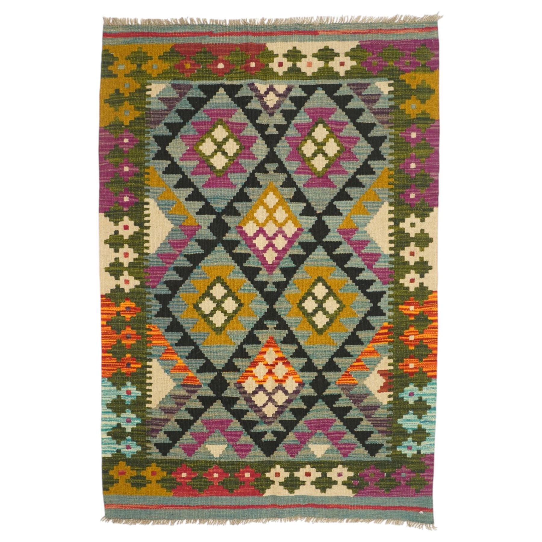 Afghan Maimana flatweave kilim, central field features large bold nested diamond motifs and stylized geometric lozenge patterns on olive purple, blue, and green tone ground, dark green border stripe, with fringe ends