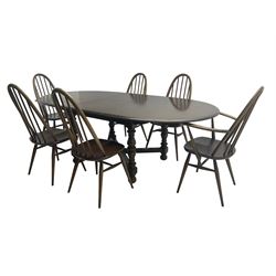Ercol - 'Old Colonial' 705 elm extending dining table, oval top with hidden leaf, raised on turned supports united by X-stretcher (W163cm D108cm H72cm); and Ercol - set six  (4+2) dark elm 'Quaker Back Windsor Dining Chairs', hoop and stick backs 