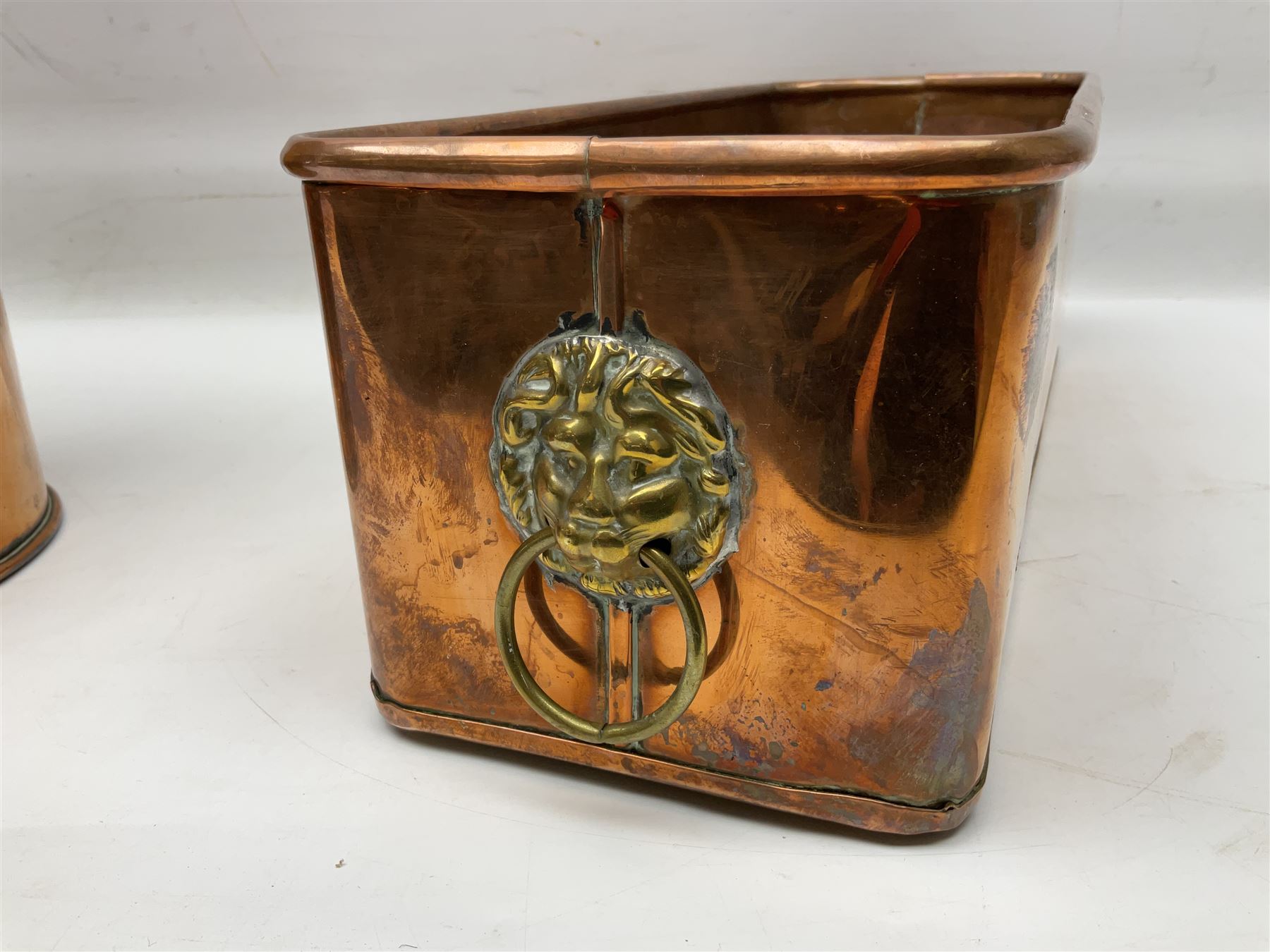 Victorian copper hot water urn, the body of plain cylindrical form with brass tap, the slightly domed lid with brass finial, together with a rectangular copper planter, with twin brass lion mask handles, urn H35cm