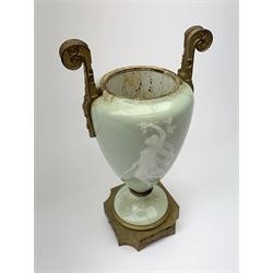 A pate sur pate celadon green vase, of baluster form decorated with a classical female figure to one side, and floral swag with ribbon and musical trophy to the other, with twin gilded scroll handles, and raised upon a gilded base, overall H38.5cm. 