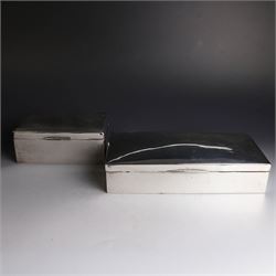 Two silver cigarette boxes, comprising early 20th century plain rectangular example with compartmentalised softwood interior, hallmarked Birmingham 1914, maker's mark indistinct, and an early 20th century example with engine turned decoration and engraved initials to cover, hallmarks worn and indistinct, largest H4.5cm, W21cm