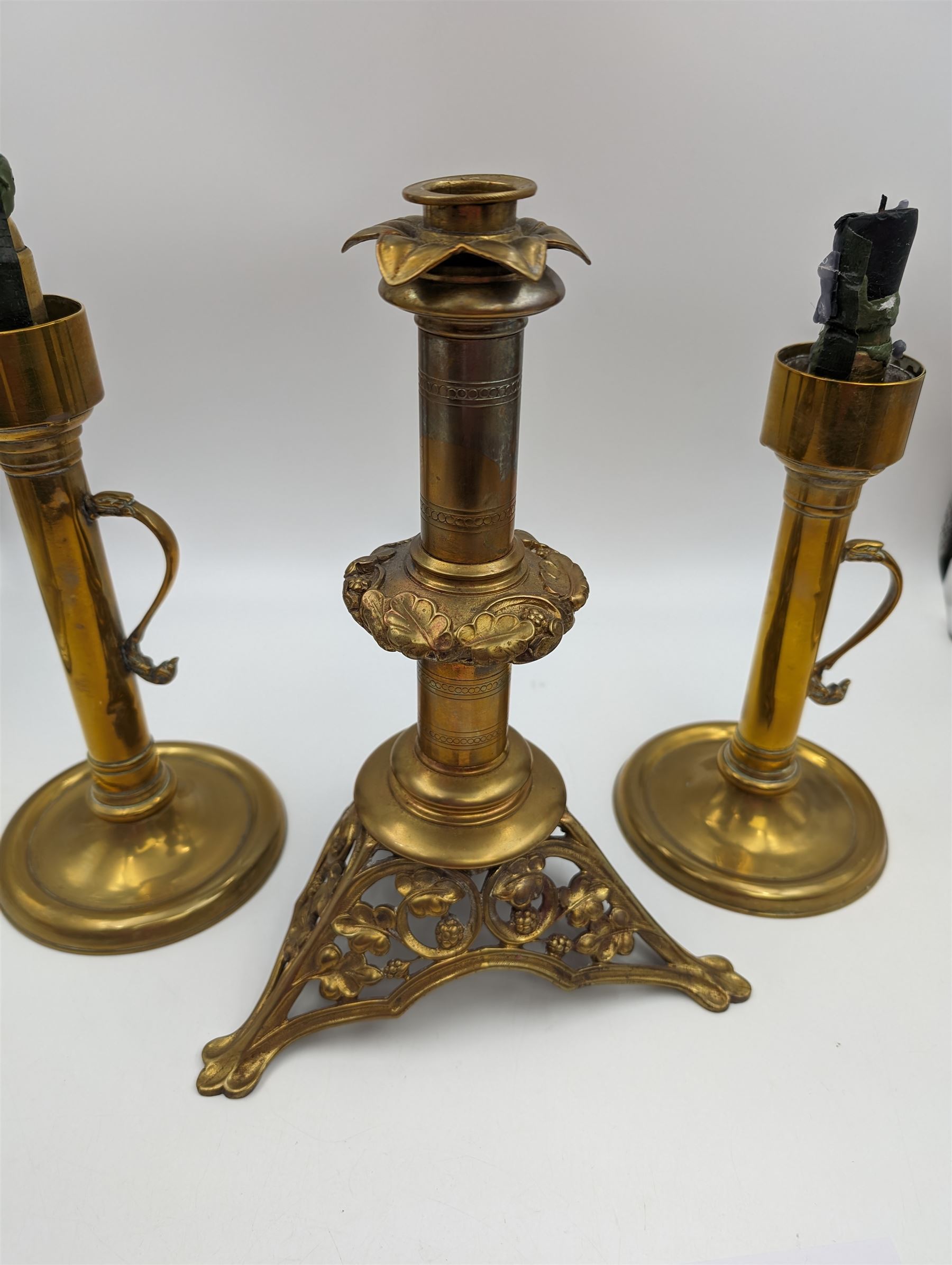 Brass candlestick with a knopt stems and triform base, together with two other brass candlestick 