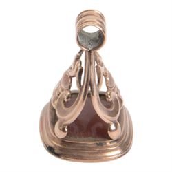 Late 18th/early 19th century 9ct gold fob seal, the carnelian matrix engraved with coat of arms, depicting a shield surmounted by a bird with foliage within its beak, within a scrolling mount detailed with a bird drinking from a chalice, H3.5cm 

Provenance: By family descent from the Chichesters of Arlington Court, Devon; from the collection of Andrew Chichester Everitt.