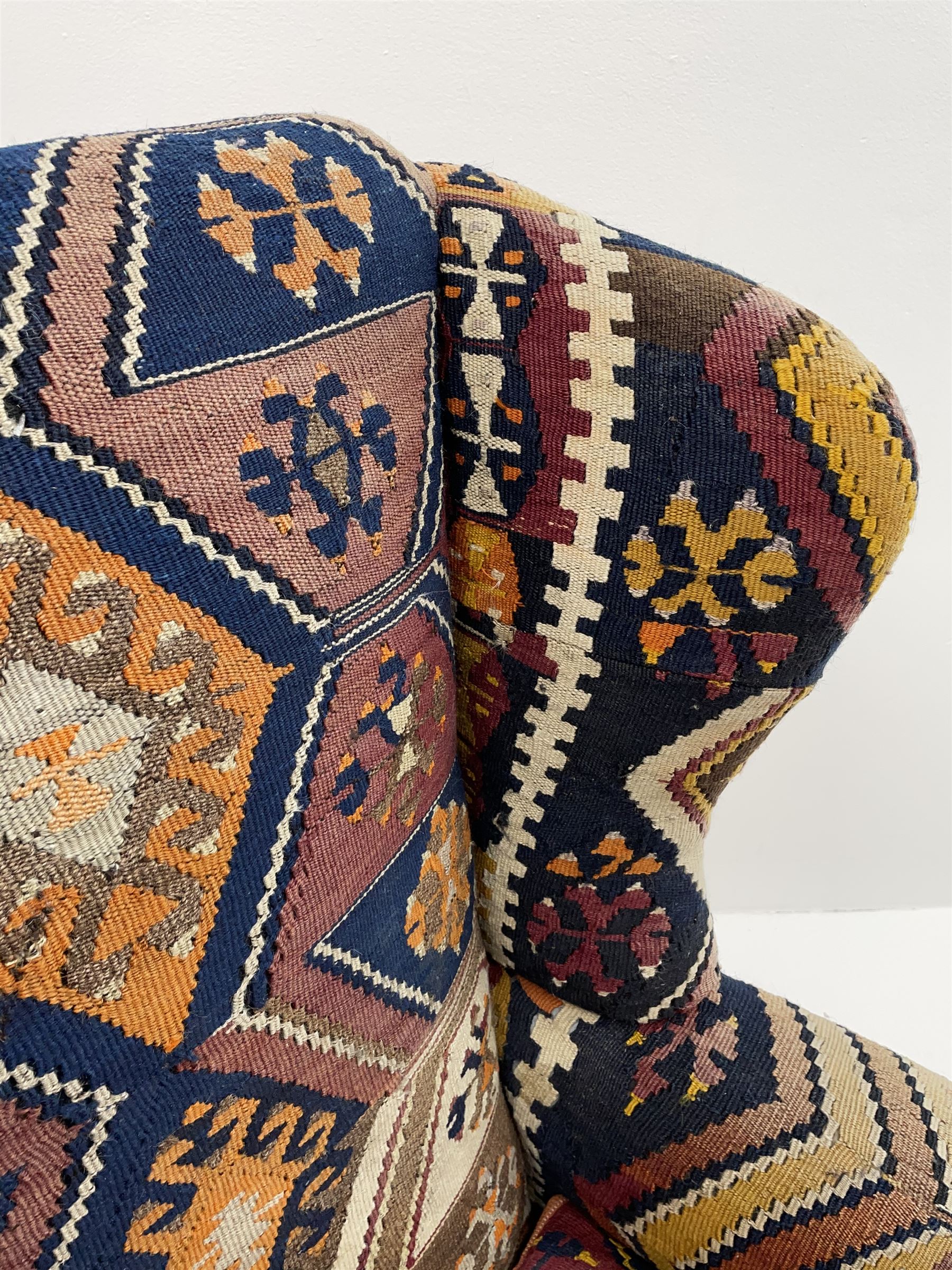Late 20th century beech framed wingback armchair, sprung seat and back upholstered in kilim cover, acanthus carved cabriole supports with ball and claw feet
