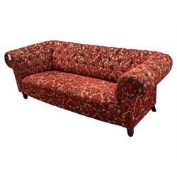 Late 20th century upholstered Chesterfield sofa, in red damask floral fabric, with deep buttoned back and arms, scrolled arms at equal height to back, on turned front supports