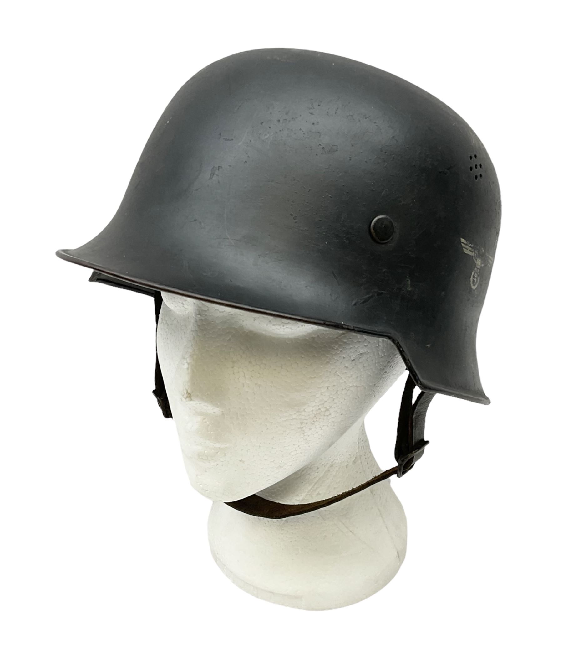 WW2 German steel combat helmet with eagle insignia to one side and U-724 to the other, leather liner marked No.56 and leather chin strap; indistinctly stamped to the skirt '*ahl'