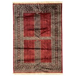Tekke Ensi crimson ground rug, the quartered field decorated with candelabra motifs, multi-guarded border with repeating geometric hexagonal lozenges in blue and ivory